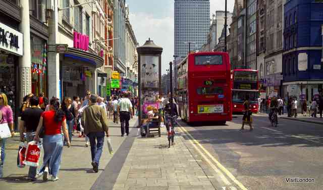 Busy scene on Oxford Street, with shoppers and double-decker buses, in London's vibrant west end shopping district